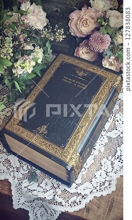 The book is titled "The Book of the Dead" and is surrounded by flowers 127838083
