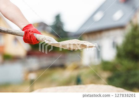 Person using shovel on construction site Person using shovel on construction site 127838201