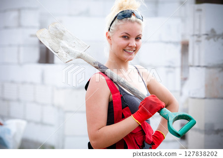 Person using shovel on construction site Person using shovel on construction site 127838202
