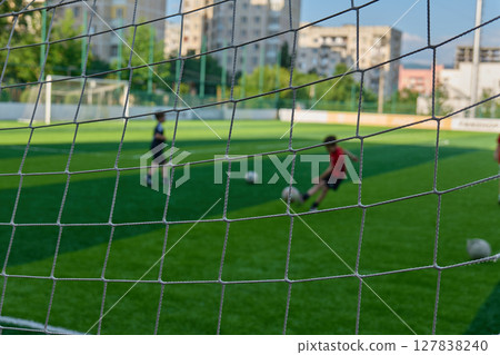 Children enjoy kicking a soccer ball on a grassy field. High quality photo Children enjoy kicking a soccer ball on a grassy field. High quality photo 127838240