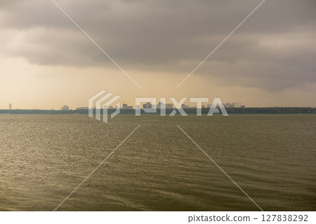 Dramatic sky over the lake with cityscape in the background Dramatic sky over the lake with cityscape in the background 127838292