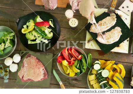 Meat and vegetable barbecue ingredients on an outdoor table 127838783
