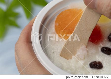 在水邊用木匙吃刨冰 在水邊用木匙吃刨冰 127840027