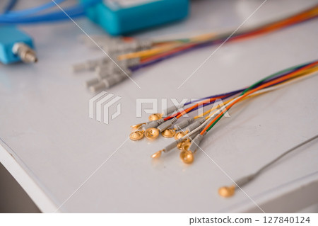 Gold EEG Electrode Array Close-Up: Medical Neurodiagnostic Tools, Colorful Cables, Clinical Research, Bright Laboratory Setting, Selective Focus Gold EEG Electrode Array Close-Up: Medical Neurodiagnostic Tools, Colorful Cables, Clinical Research, Bright Laboratory Setting, Selective Focus 127840124