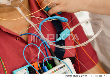 Patient Monitoring with PSG System: Chest Leads, ECG, Heart Rate Display, Medical Technology, Intensive Care, Red Shirt, Close-Up View Patient Monitoring with PSG System: Chest Leads, ECG, Heart Rate Display, Medical Technology, Intensive Care, Red Shirt, Close-Up View 127840142