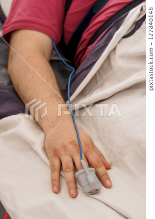 Patient Monitoring with Pulse Oximeter on Hand in Hospital Bed, Healthcare and Medical Technology Scenario in Blue and White. 127840148