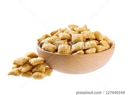 corn pillows pouring out of wooden bowl isolated on white background. 127840340