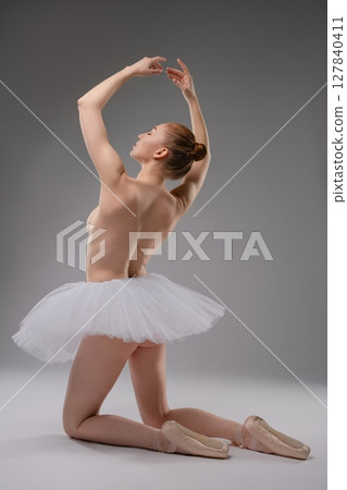 Elegant ballet dancer in a graceful pose wearing a white tutu Elegant ballet dancer in a graceful pose wearing a white tutu 127840411