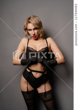 Sensual woman poses in elegant lingerie against a neutral background Sensual woman poses in elegant lingerie against a neutral background 127840465