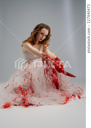 Bride in bloodstained lingerie holds katana in a hauntingly beautiful portrayal Bride in bloodstained lingerie holds katana in a hauntingly beautiful portrayal 127840473
