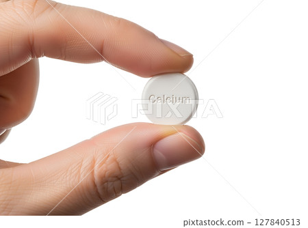 Hand holding calcium tablet isolated on transparent background, white supplement close-up 127840513