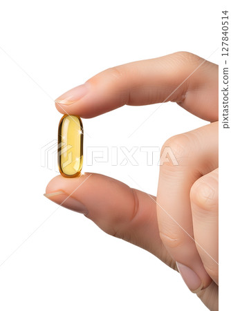 Hand presenting fish oil softgel, golden liquid visible inside, health product, dietary supplement 127840514