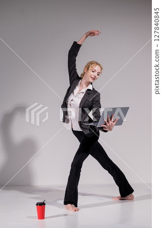 Barefoot ballerina dancing in business suit on white background. Barefoot ballerina dancing in business suit on white background. 127840845