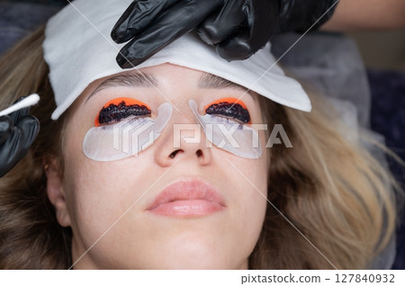 The process of professional lamination and tinting of eyelashes in the salon. The process of professional lamination and tinting of eyelashes in the salon. 127840932