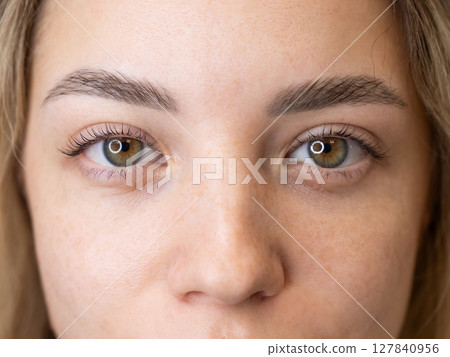 Close-up portrait of a woman after eyelash lamination procedure.  127840956
