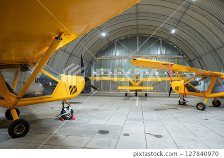 Yellow airplane glider in the hangar. Yellow airplane glider in the hangar. 127840970