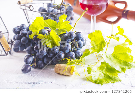 Red wine grapes on white table 127841205