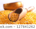 Millet in a bowl and spoon with twigs on a table. 127841262