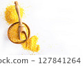 Millet in a bowl and spoon with twigs on a table. 127841264