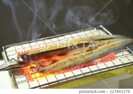 在炭火上烤秋刀魚片,煙霧繚繞 在炭火上烤秋刀魚片,煙霧繚繞 127841279