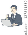 A man in a suit drinking coffee and looking at a computer 127841830