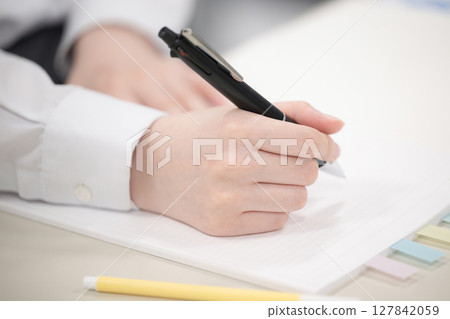 Studying during school or cram school classes; serious and earnest image of exam preparation; hands without face 127842059