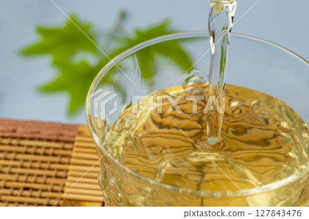 Image of drinking cold green tea by the water to cool off Cold tea made in a teapot Image of drinking cold green tea by the water to cool off Cold tea made in a teapot 127843476