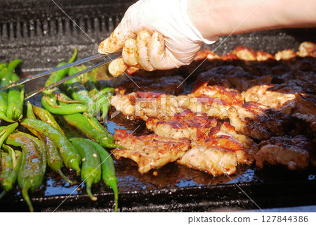Beef and chicken steaks on the grill with flames. 127844386