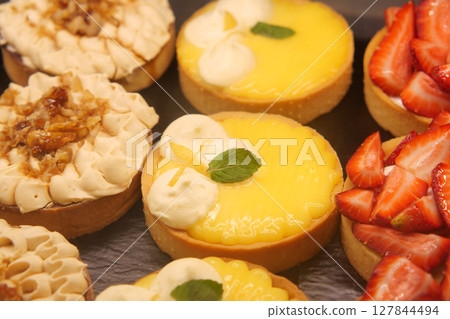 Delicious dessert tarts displayed on rustic table Delicious dessert tarts displayed on rustic table 127844494