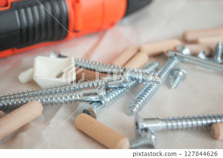 Tools and fasteners arranged on a work surface for assembly 127844626