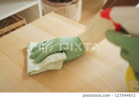Cleaning a wooden surface with gloves and cloth Cleaning a wooden surface with gloves and cloth 127844652