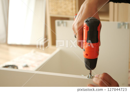 DIY furniture assembly using a cordless drill at home 127844723