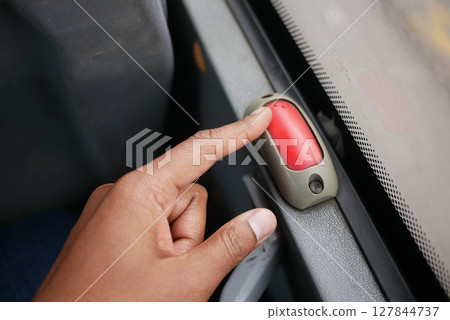 Passenger signals to stop bus with red button 127844737