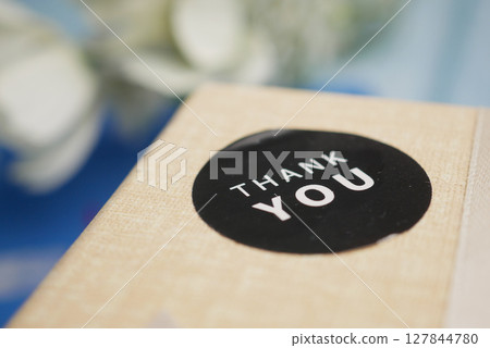 Surprise package with a thank you sticker on the lid 127844780