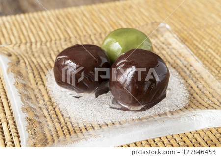 Red bean paste balls on a glass plate, creating a cool atmosphere Natural light 127846453