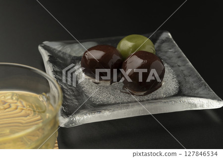 Red bean paste balls on a glass plate with a cool look Black background 127846534