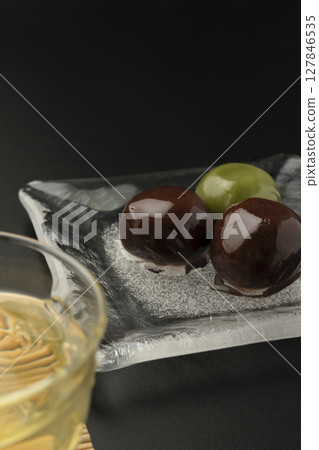 Red bean paste balls on a glass plate with a cool look Black background 127846535