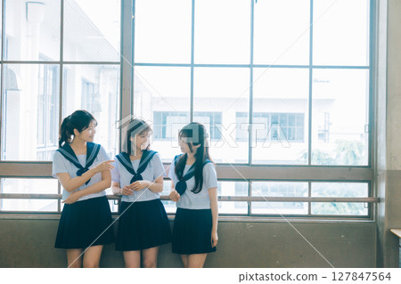 三個高中女生在教室裡聊天 127847564