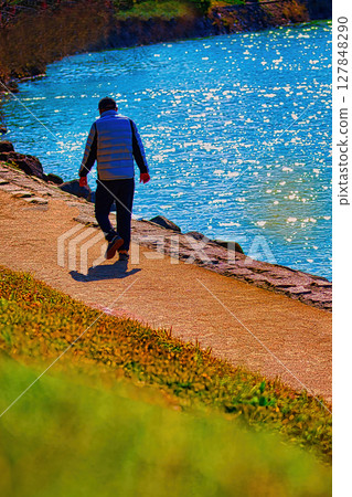 People walking in the park along the river 127848290