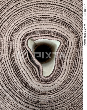 close-up view rolled fabric intricate texture and soft color tones at textile workshop. 127848314