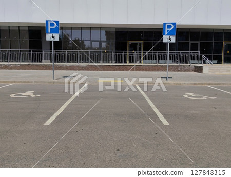 new accessible parking spaces in modern building complex at midday. 127848315