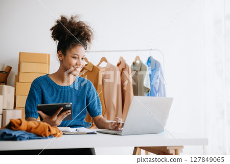 Fashion blogger concept, Young African women selling clothes on video streaming.Startup small business SME, using smartphone or tablet 127849065