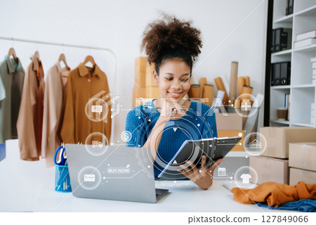 Young woman running online store Startup small business SME, using smartphone or tablet taking receive and checking online purchase shopping order 127849066