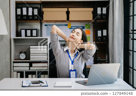 Asian woman feeling migraine head strain.Overworked businesswoman financier while working on laptop and tablet Asian woman feeling migraine head strain.Overworked businesswoman financier while working on laptop and tablet 127849148