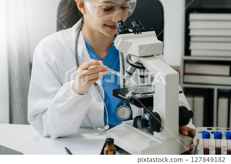 female scientist working with micro pipettes analyzing biochemical samples, advanced science chemical laboratory for medicine. 127849182