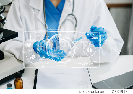 DNA molecule testing concepts. The doctor in a mask examines DNA molecules on the chemical laboratory with virtual icon DNA molecule testing concepts. The doctor in a mask examines DNA molecules on the chemical laboratory with virtual icon 127849183