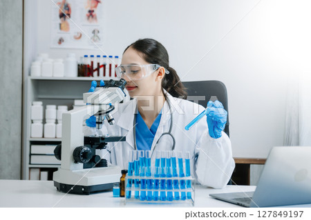 female scientist working with micro pipettes analyzing biochemical samples, advanced science chemical laboratory for medicine. 127849197