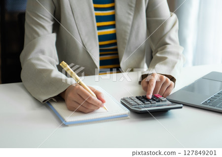 Businessman hands working with finances about cost and calculator and laptop with tablet, smartphone at office Businessman hands working with finances about cost and calculator and laptop with tablet, smartphone at office 127849201