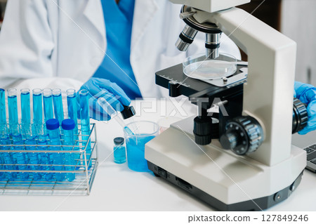 Modern medical research laboratory. female scientist working with micro pipettes analyzing biochemical samples, advanced science chemical laboratory 127849246