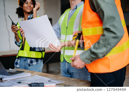 Engineer Teamwork Meeting, Drawing working on blueprint meeting for project working with partner on model building at company office. Engineer Teamwork Meeting, Drawing working on blueprint meeting for project working with partner on model building at company office. 127849499